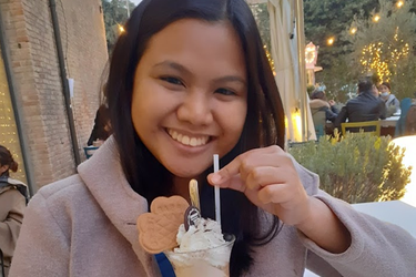 Audrey smiling while having a gelato in a cafè Cesena