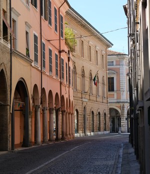 A street with houses and porticoes in the city center of Cesena