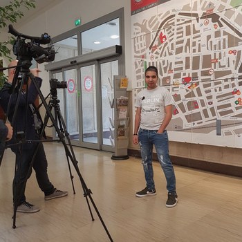 Tareq in front of a camera crew