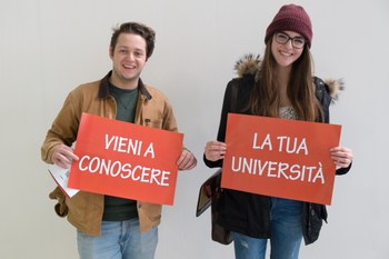 studenti con cartelli di promozione unibo